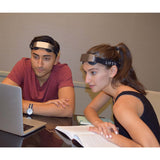 An image of a man and woman both wearing a liftid tdcs device while watching something on a laptop